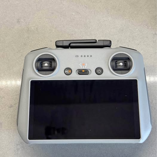 Gray drone remote controller with screen and dual joysticks