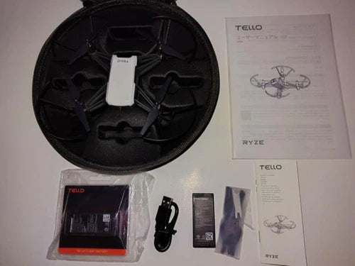 Mini quadcopter drone kit with black carrying case, batteries, and instruction manuals