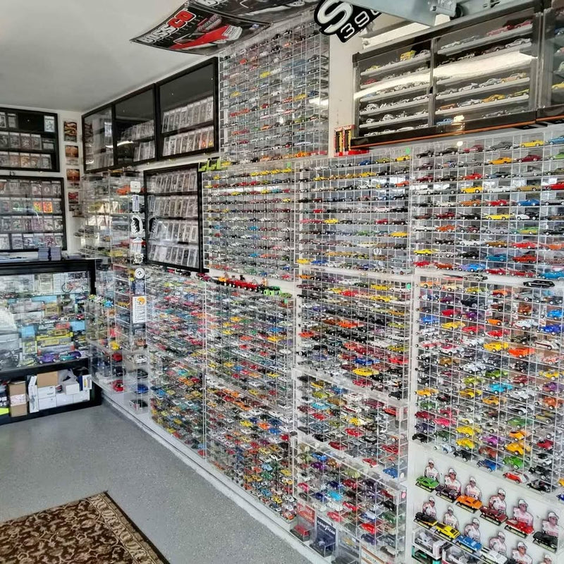 Diecast toy car display on store shelves with many small vehicles in blister packs