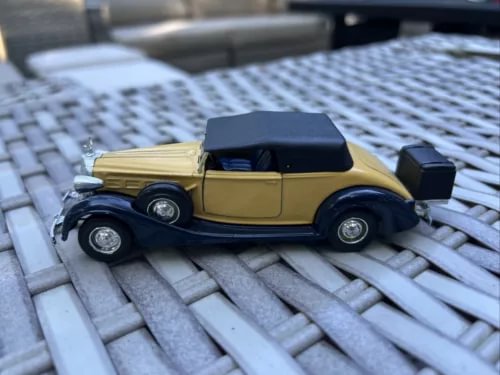 Yellow and dark blue diecast car model, side view, 1:43 scale