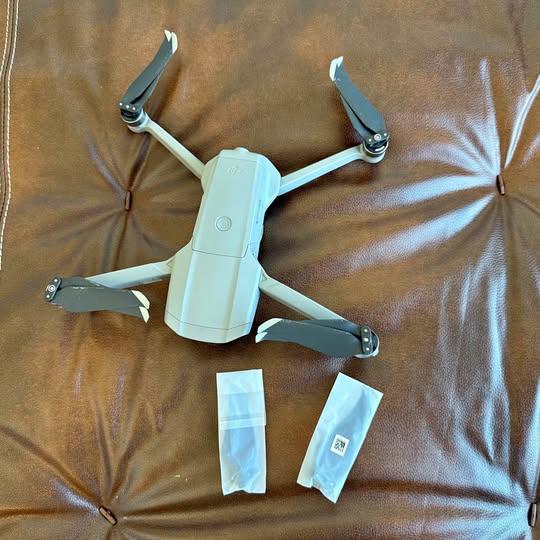DJI Mavic Air 2 drone with folded propellers, plus two accessory sleeves