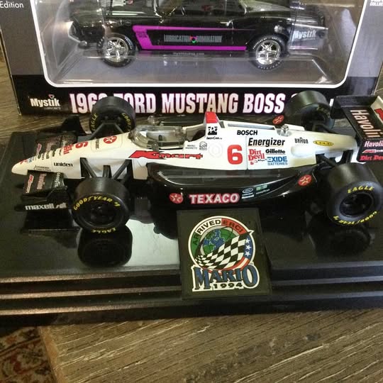 1:24 diecast race car model, black with purple stripe, chrome wheels in box