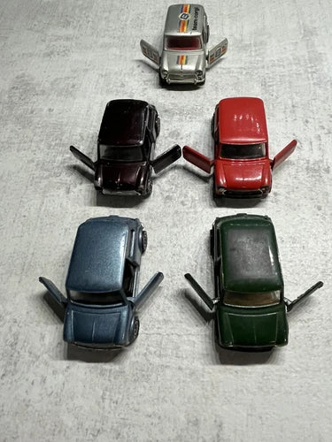 Five mini diecast toy cars in red, black, blue, dark green, and silver.