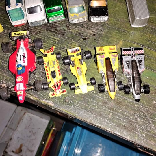 Assorted diecast race cars set, colorful vehicles with wheels, top view.