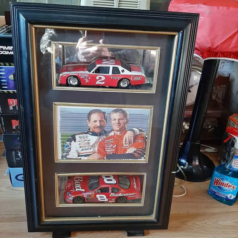 Black glass display case with diecast race car replicas and driver photos