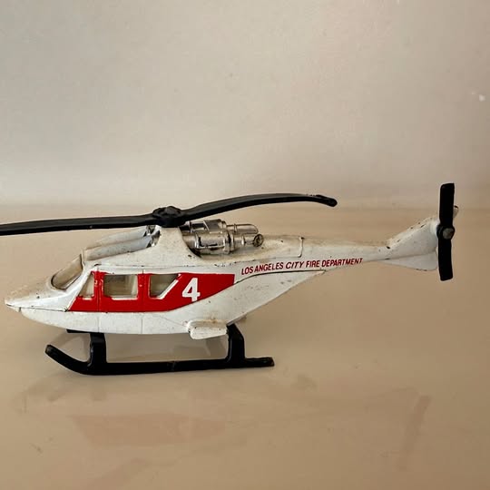 Diecast helicopter model with white body, red stripe, number 4, black skids and tail rotor