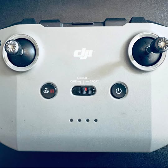White DJI remote controller with dual thumb joysticks and control buttons