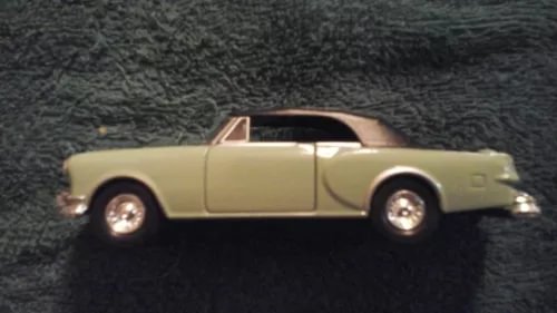 Cream convertible diecast model car with dark roof and interior