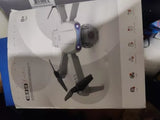 Compact white quadcopter drone in retail box with visible propellers