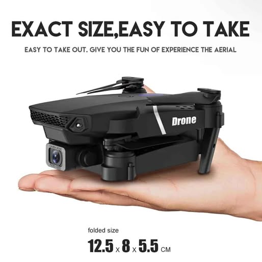 Foldable black quadcopter drone with camera and front sensors, folded on hand