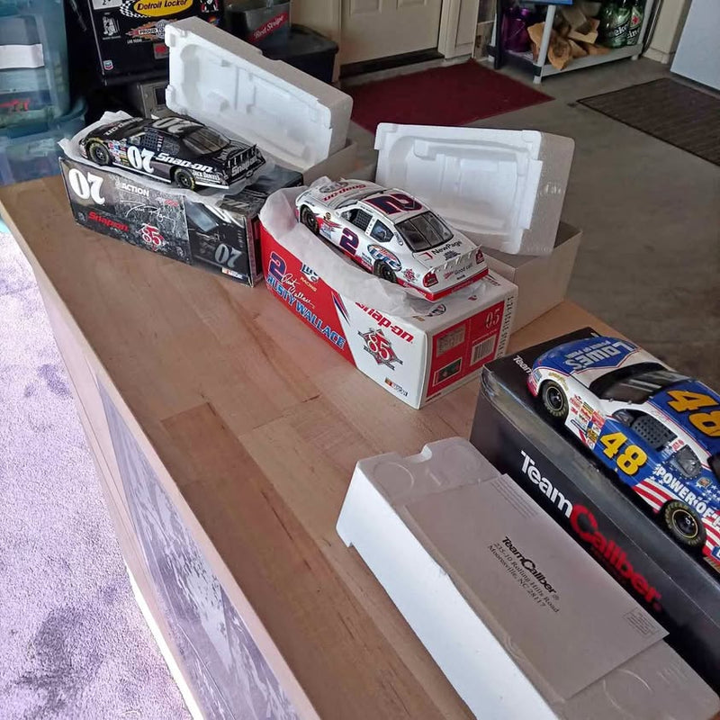 1/24 scale NASCAR diecast red-and-white race car in box, with extra cars