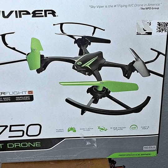 Stunt drone with black body and green quad propellers, visible from front