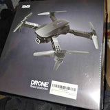 Foldable quadcopter drone with four propellers, shown on gray product box