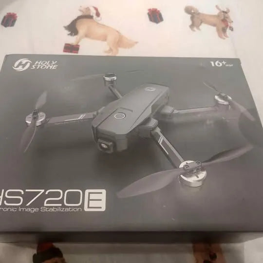 Gray quadcopter drone with four propellers on retail box, 16x zoom