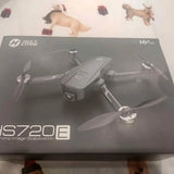 Gray quadcopter drone with four propellers on retail box, 16x zoom