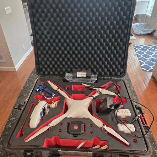 Quadcopter drone in open hard case, with controller and batteries