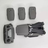 Grey foldable quadcopter drone with propellers and three spare batteries