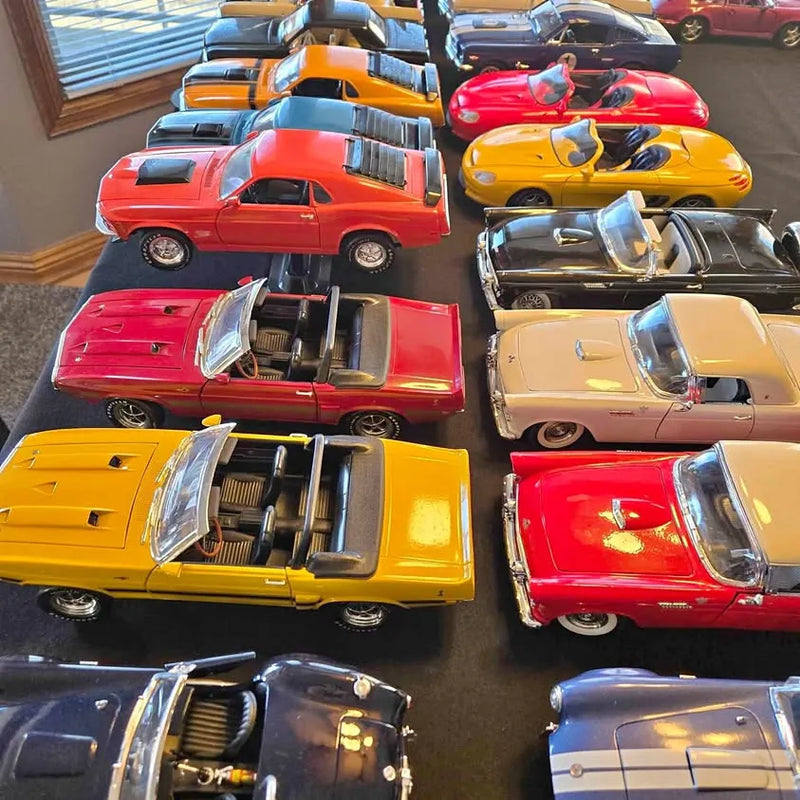 Assorted 1:18 scale diecast collectible cars, red, yellow, orange, and light blue