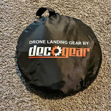 Black circular drone landing gear with drawstring bag and logo text