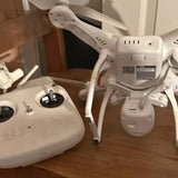 White DJI drone with four propellers, top and controller mounts visible
