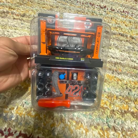 Orange and black diecast toy car in clear blister package with number 42