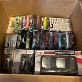 Assorted die-cast model cars in retail packaging, including Maisto Premier DC models