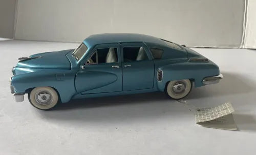 Vintage blue diecast 1948 Tucker car, side profile with whitewall wheels
