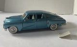 Vintage blue diecast 1948 Tucker car, side profile with whitewall wheels
