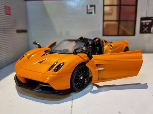 Orange diecast roadster model with black wheels and open side doors, 1:24