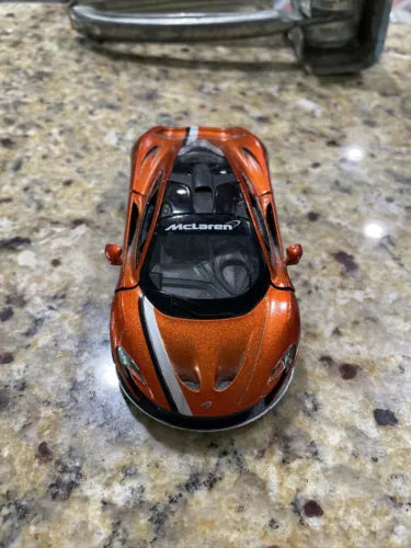 Orange diecast toy car with black windshield and McLaren P1 logo on hood, front view
