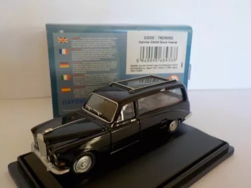 Black diecast hearse model car on display base, front three-quarter view