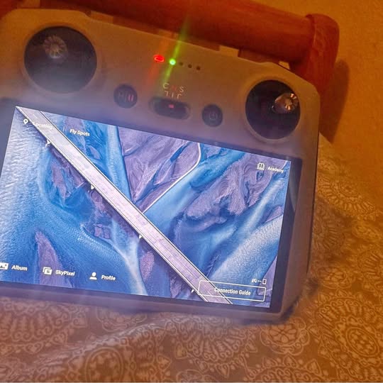 Orange RC drone controller with dual thumbsticks and built-in screen display