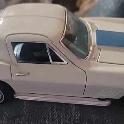 Beige diecast sports car model, side view with front window and door details.