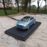 Blue diecast sedan model car on display base, front 3/4 view