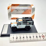 Light blue diecast SUV toy car with roof rack and grille, on display base with ruler