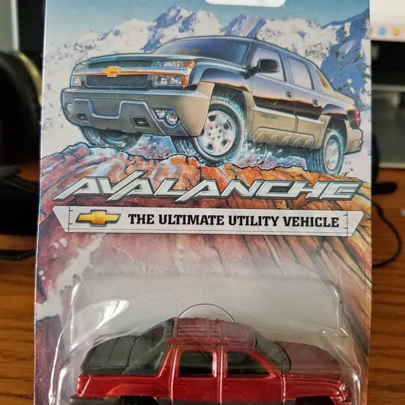 Red Chevrolet Avalanche diecast pickup truck model, black roof and grille details
