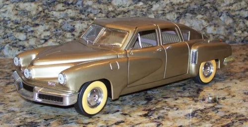 1:18 diecast model car, gold-toned 1948 Tucker Torpedo, front-side view