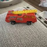 Red diecast fire pumper truck with yellow ladder and detailed front grille