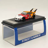 Diecast race car model, red and orange with rear wing, on Street Warrior display base