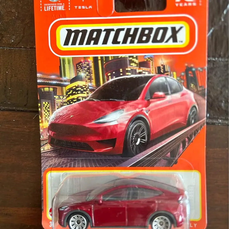 Red die-cast metal Tesla Model Y car with black wheels, packaged in Matchbox box
