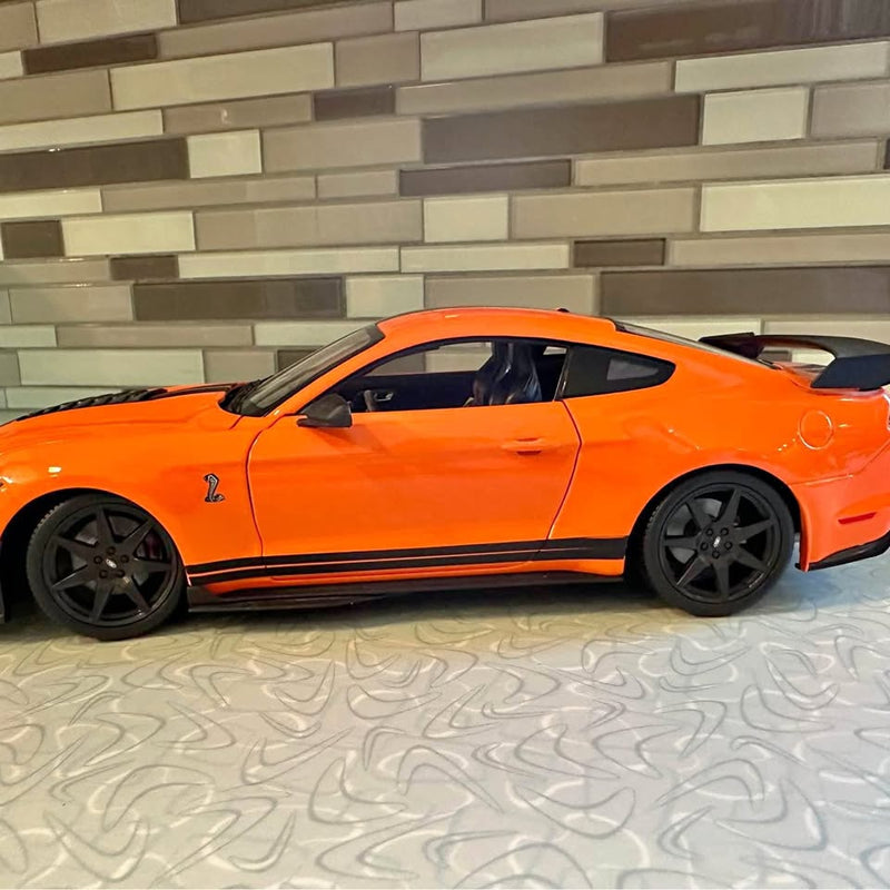 Orange diecast model car, black wheels, side view, detailed body lines