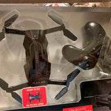Black quadcopter drone with folded arms, in clear retail box packaging.