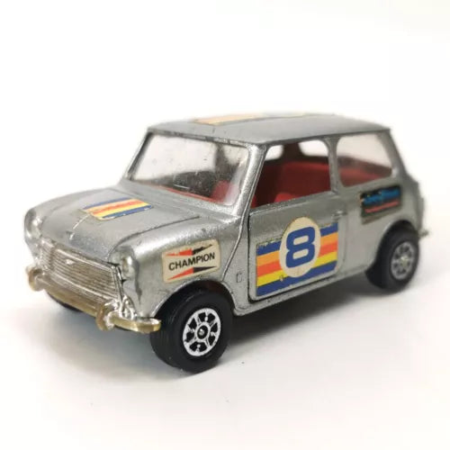 Silver diecast Mini Cooper model car with blue-yellow #8 race decals and Champion logo