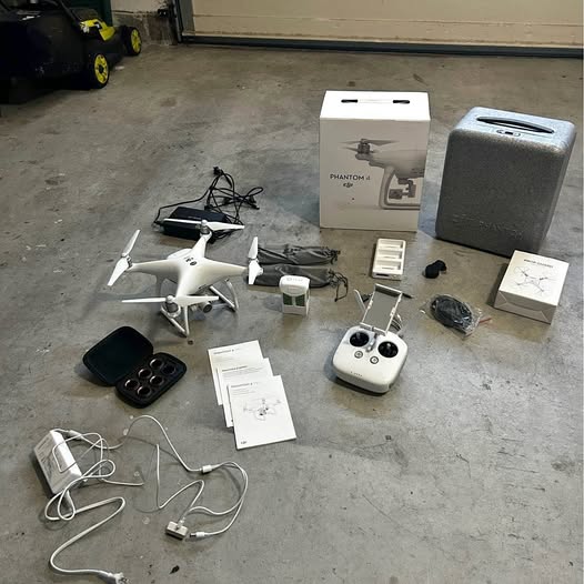 White quadcopter drone kit with remote controller, camera gimbal, and accessory boxes