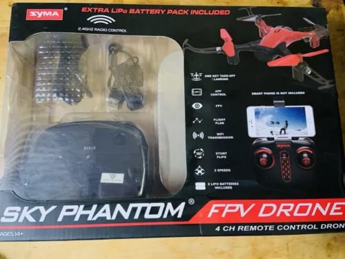 FPV drone kit in retail box with red quadcopter and remote control