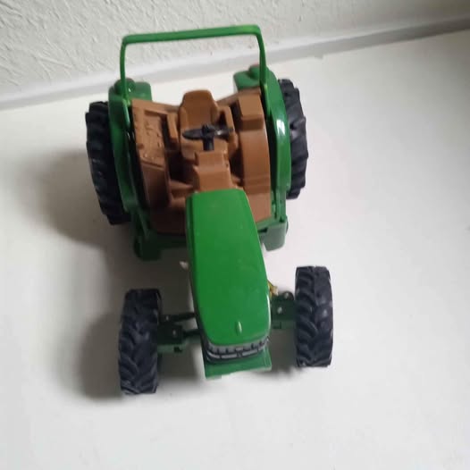 Green and brown diecast tractor toy with trailer, four rugged tires