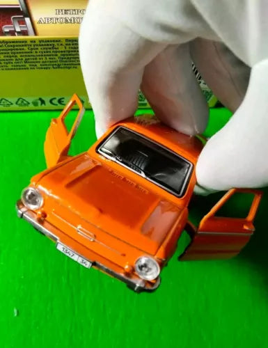 Orange diecast toy car with open door, 1:36 scale, front view