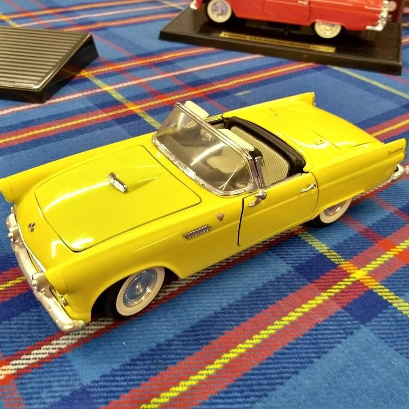 Yellow 1955 Ford Thunderbird convertible diecast model, front side view with chrome details