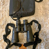 Binoculars with attached black carrying strap and protective lens caps