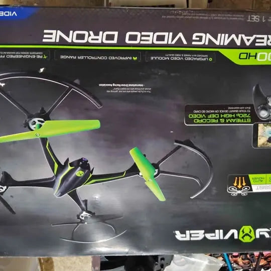 Green and black quadcopter drone with four propellers on retail box